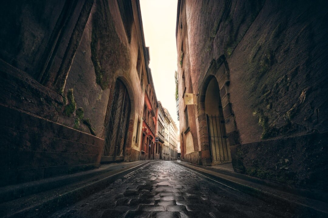 Dark atmospheric alley in old town resembling a mystery novel cover scene